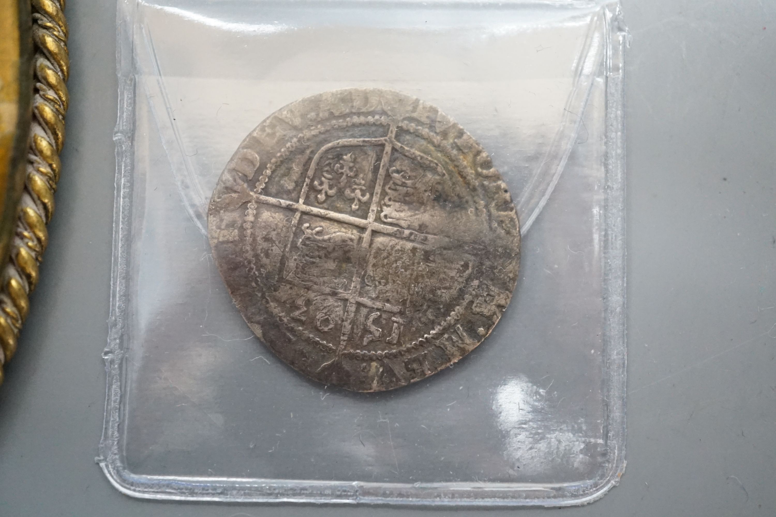 An Elizabeth I 1593 sixpence and a oval portrait frame the reverse depicting Elizabeth I coat of arms.